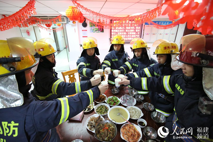 漳州消防特勤大隊一中隊消防指戰(zhàn)員歡聚一堂，吃年夜飯，舉杯共飲。