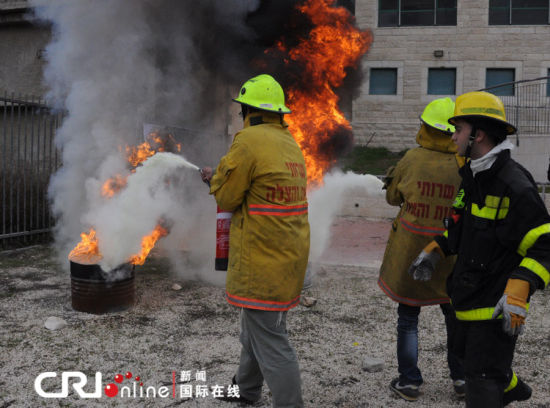 兩名志愿者在消防員的指揮下滅火。（攝影：張瑾） 