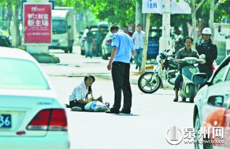 女孩從摩的上摔下，跌坐路中央，恰遇社區(qū)聯(lián)防巡邏人員扶起。