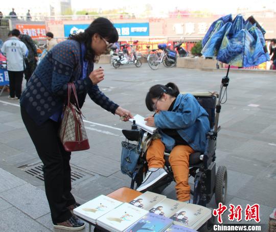 洛洛正在給買書的顧客簽名。 馮曉林 攝