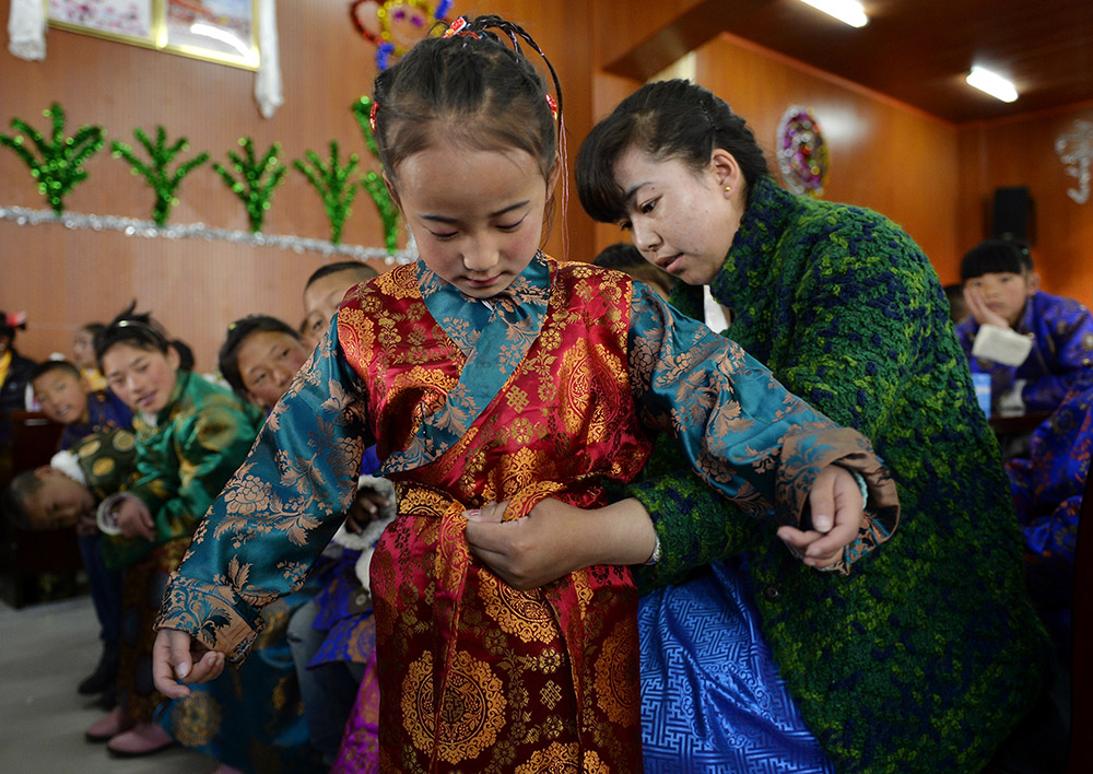 2月27日，在西藏自治區(qū)兒童福利院，來自拉薩市尼木縣的“愛心媽媽”德慶旺姆（右）在為來自那曲地區(qū)的嘎瑪曲宗換上節(jié)日盛裝。